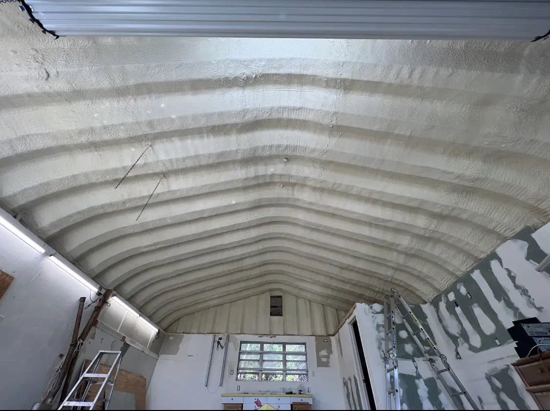 Spray polyurethane foam applied to the underside of a metal roof deck in Clay